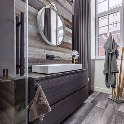 Интерьер ванной комнаты с серыми деревянными досками за morror и мойки