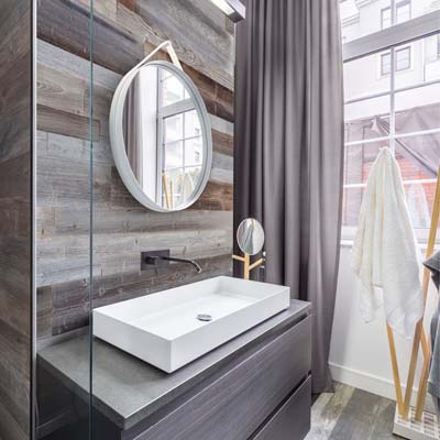 Интерьер ванной комнаты с серыми деревянными досками за morror и мойки