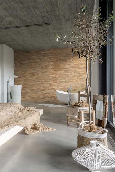 Reclaimed wood wall panels in bedroom with standalone bathtub