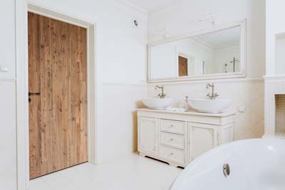 Reclaimed wood doors in white bathroom