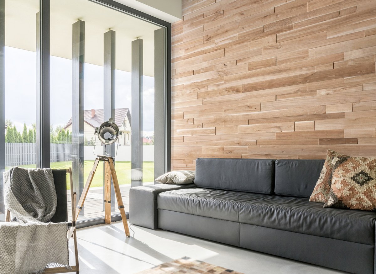 Wood wall panels next to a large window with natural sunlight in the room